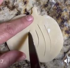 pumpkin dough being slit with knife